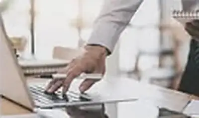 Hands typing on a laptop keyboard